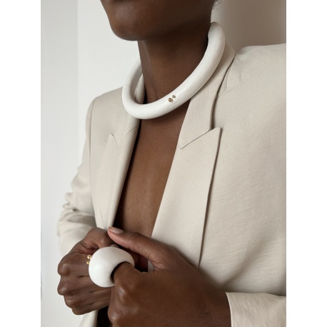 <p>Rigid choker lined in white nappa leather with detail of two asymmetrical 18k gold plated balls balls. It is very light and has a safety chain on the back of the neck (optional).</p>
<p></p>